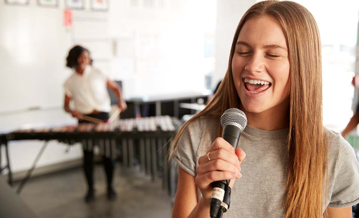 Students At Performing Arts School Playing In Band At Rehearsal